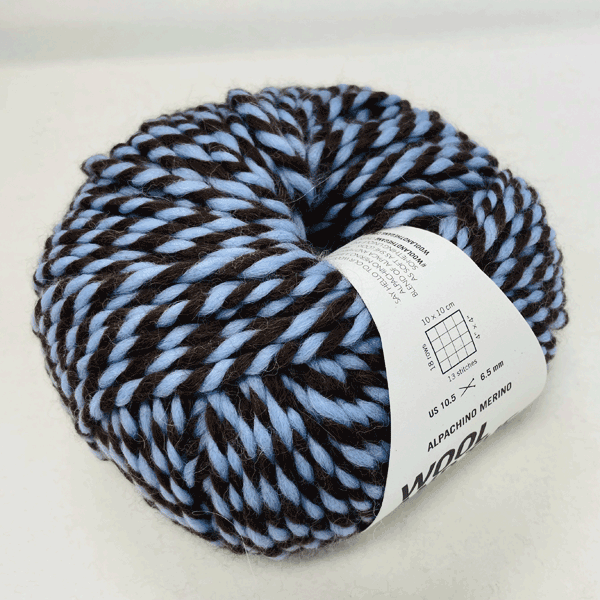 Alpachino Merino, Ball of blue and black yarn with a label on a white background