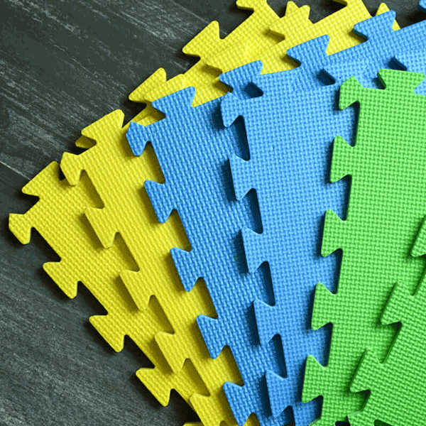 Blocking Mats - A set of interlocking blocking mats in teal, blue, and yellow colors with floral prints, laid out on a wooden surface.